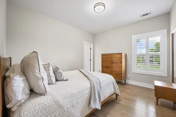 a bedroom with a bed and wooden floor