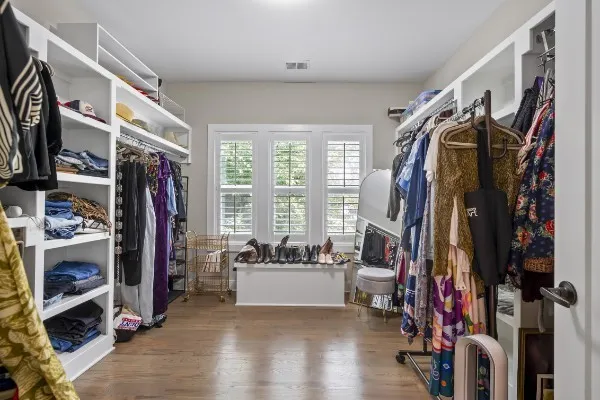 a view of walk in closet with clothes and shoes