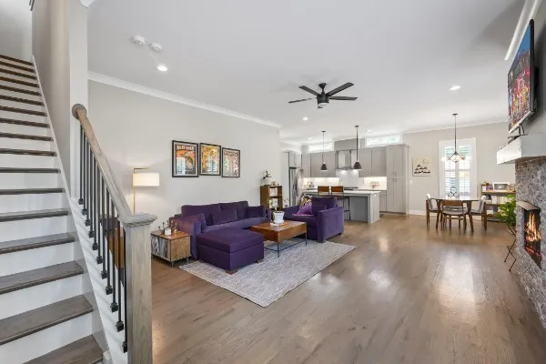 a living room with furniture kitchen view and a wooden floor