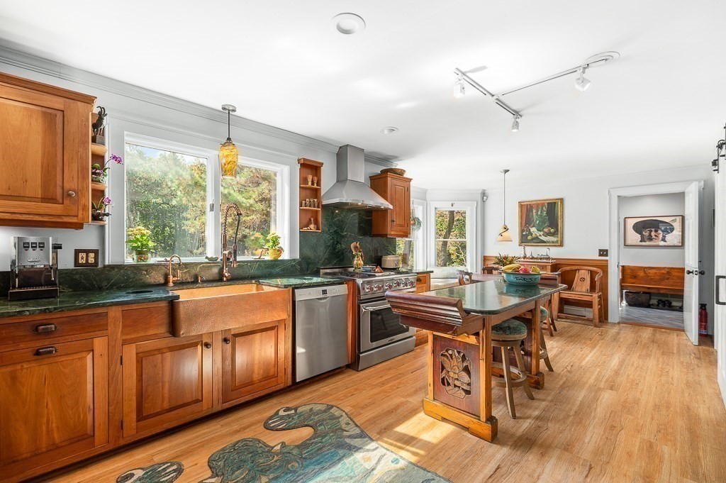 25 Leverett Street Gloucester, MA 01930 - Photo 12 of 41 a kitchen with stainless steel appliances granite countertop sink stove and wooden cabinets