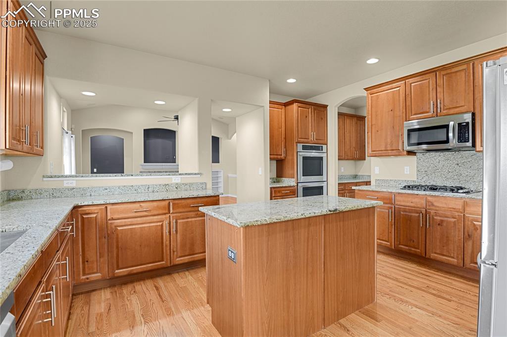 10530 Pictured Rocks Drive Peyton, CO 80831 - Photo 12 of 50 a large kitchen with stainless steel appliances granite countertop a large stove a sink and a microwave