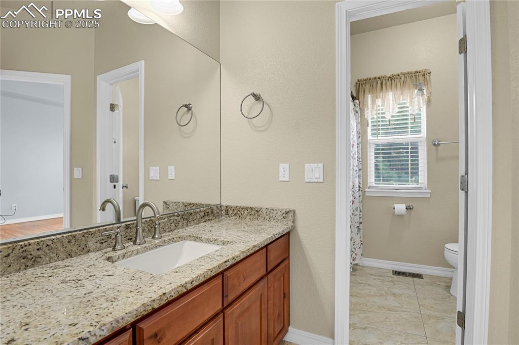 10530 Pictured Rocks Drive Peyton, CO 80831 - Photo 22 of 50 a bathroom with a granite countertop sink and a mirror