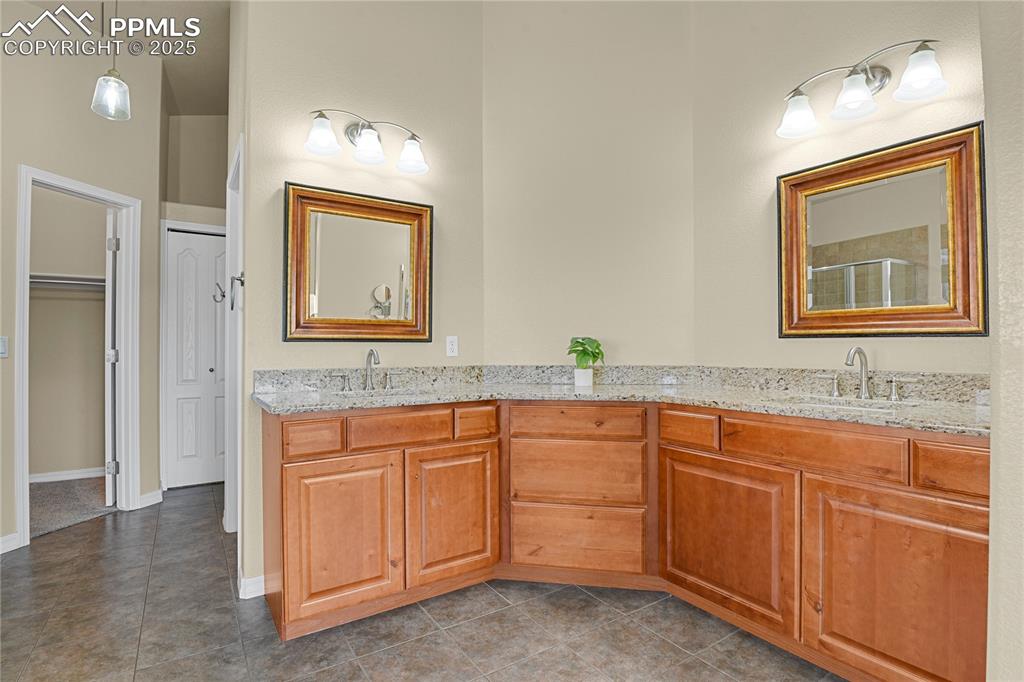 10530 Pictured Rocks Drive Peyton, CO 80831 - Photo 27 of 50 a bathroom with a granite countertop sink a toilet a mirror and vanity