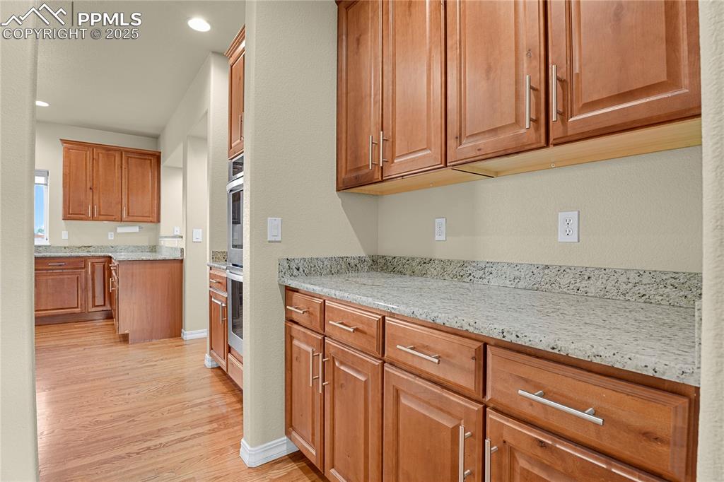 10530 Pictured Rocks Drive Peyton, CO 80831 - Photo 9 of 50 a kitchen with granite countertop wooden cabinets a sink and dishwasher