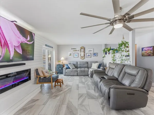 a living room with stainless steel appliances kitchen island granite countertop furniture a rug and a kitchen view