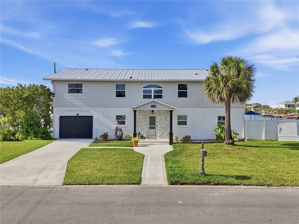 3173 Gulfview Drive Hernando Beach, FL 34607 - Photo 2 of 75 a front view of a house with garden and trees