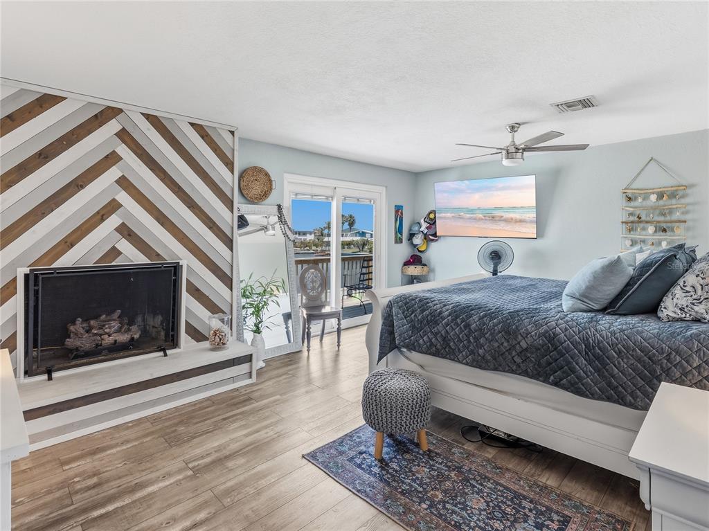 3173 Gulfview Drive Hernando Beach, FL 34607 - Photo 24 of 75 a bedroom with a bed a fireplace and a window
