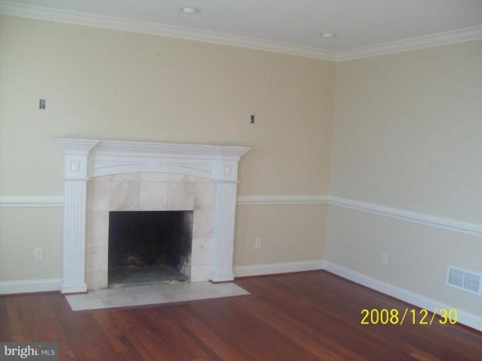 2880 Ridge Road Westminster, MD 21157 - Photo 8 of 10 a view of an empty room with wooden floor and a fireplace