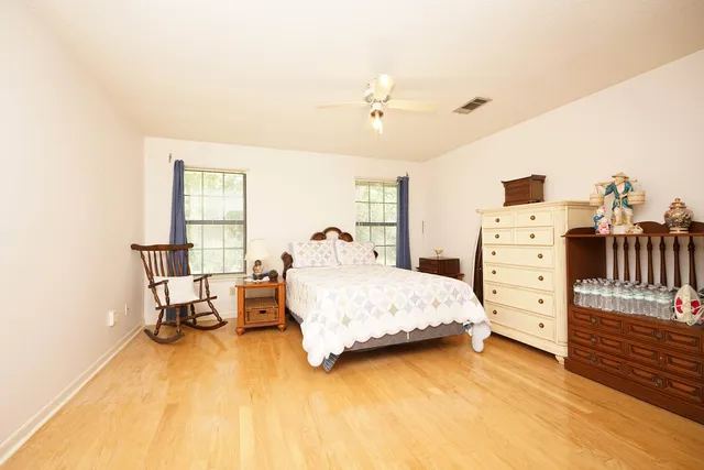 a spacious bedroom with a bed and a dresser