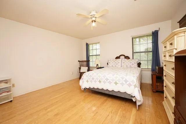 a bedroom with a bed a window and a ceiling fan