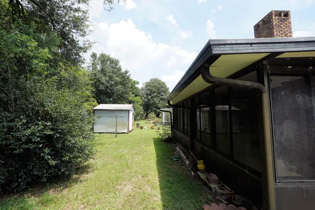 a view of a backyard with couches under an umbrella