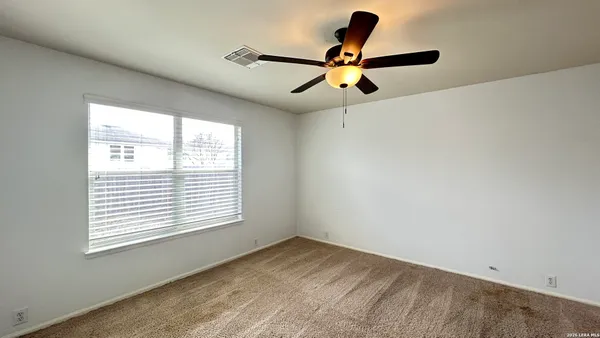 a view of room window and a ceiling fan