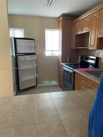 a kitchen with a stove a microwave and a refrigerator