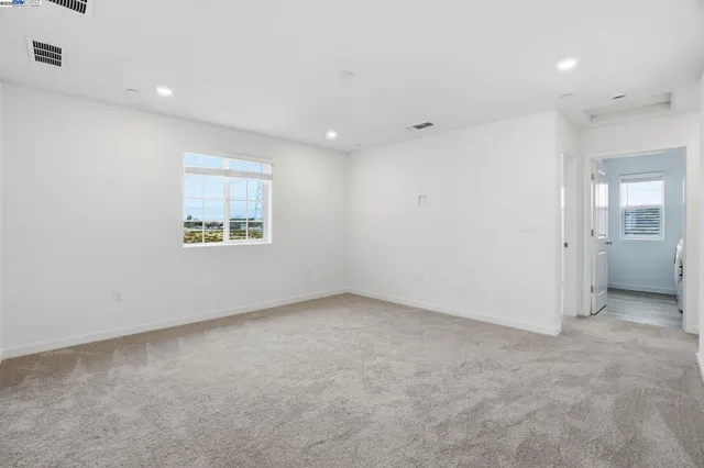 an empty room with a bathroom and a window