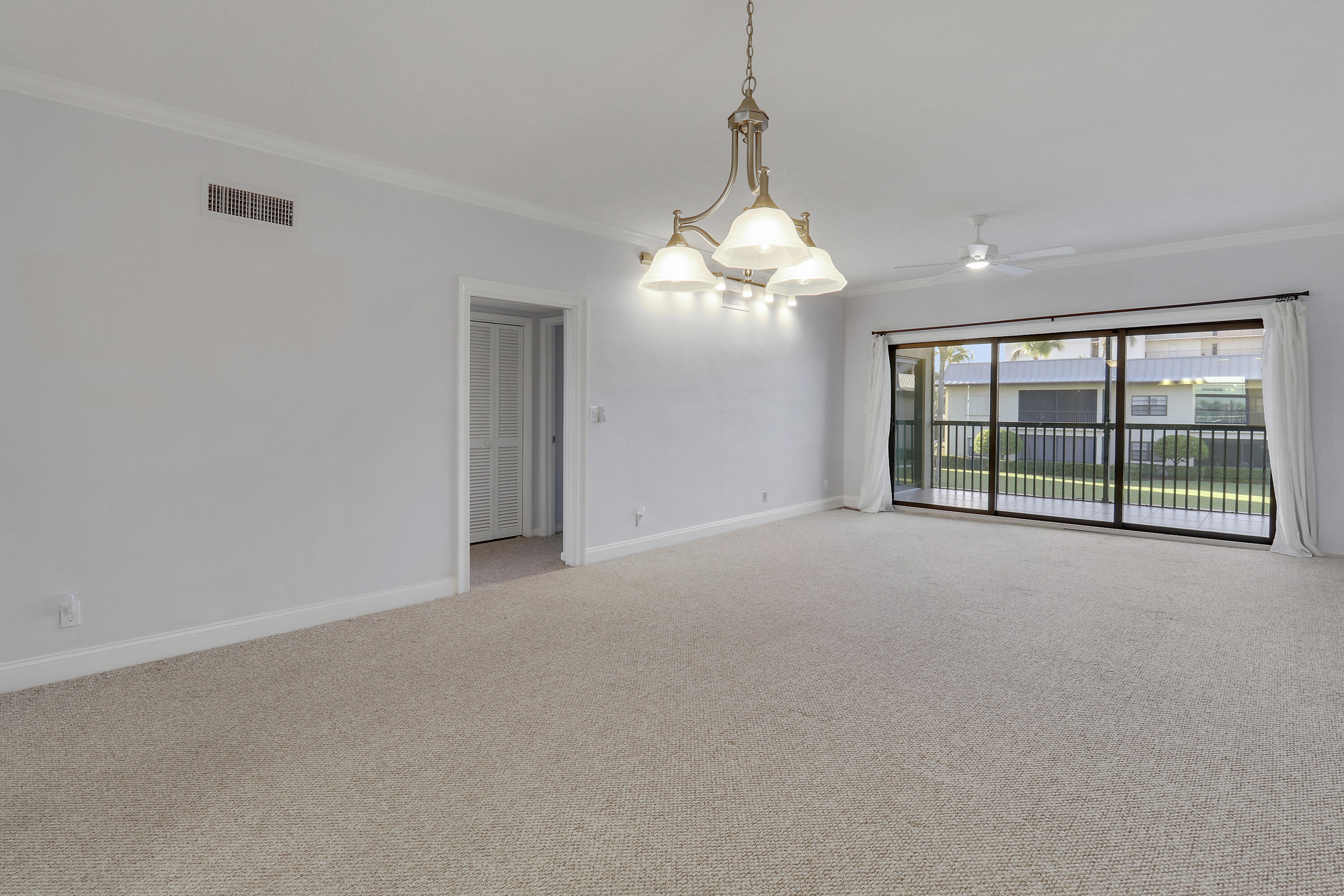 275 South Beach Road, Unit B202 Tequesta, FL 33469 - Photo 20 of 37 a view of a livingroom with a chandelier a ceiling fan and windows