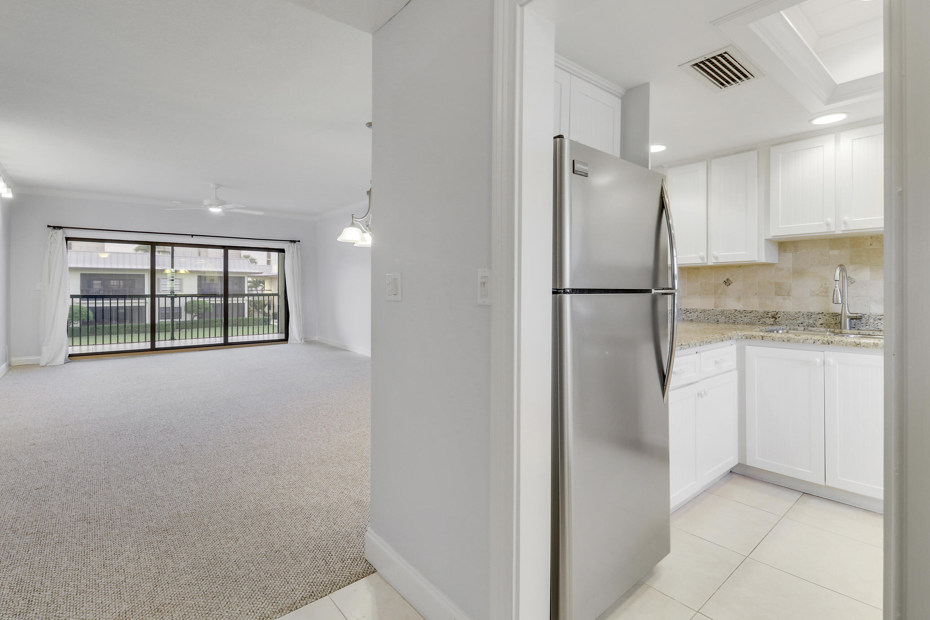 275 South Beach Road, Unit B202 Tequesta, FL 33469 - Photo 27 of 37 a kitchen with a refrigerator and white cabinets