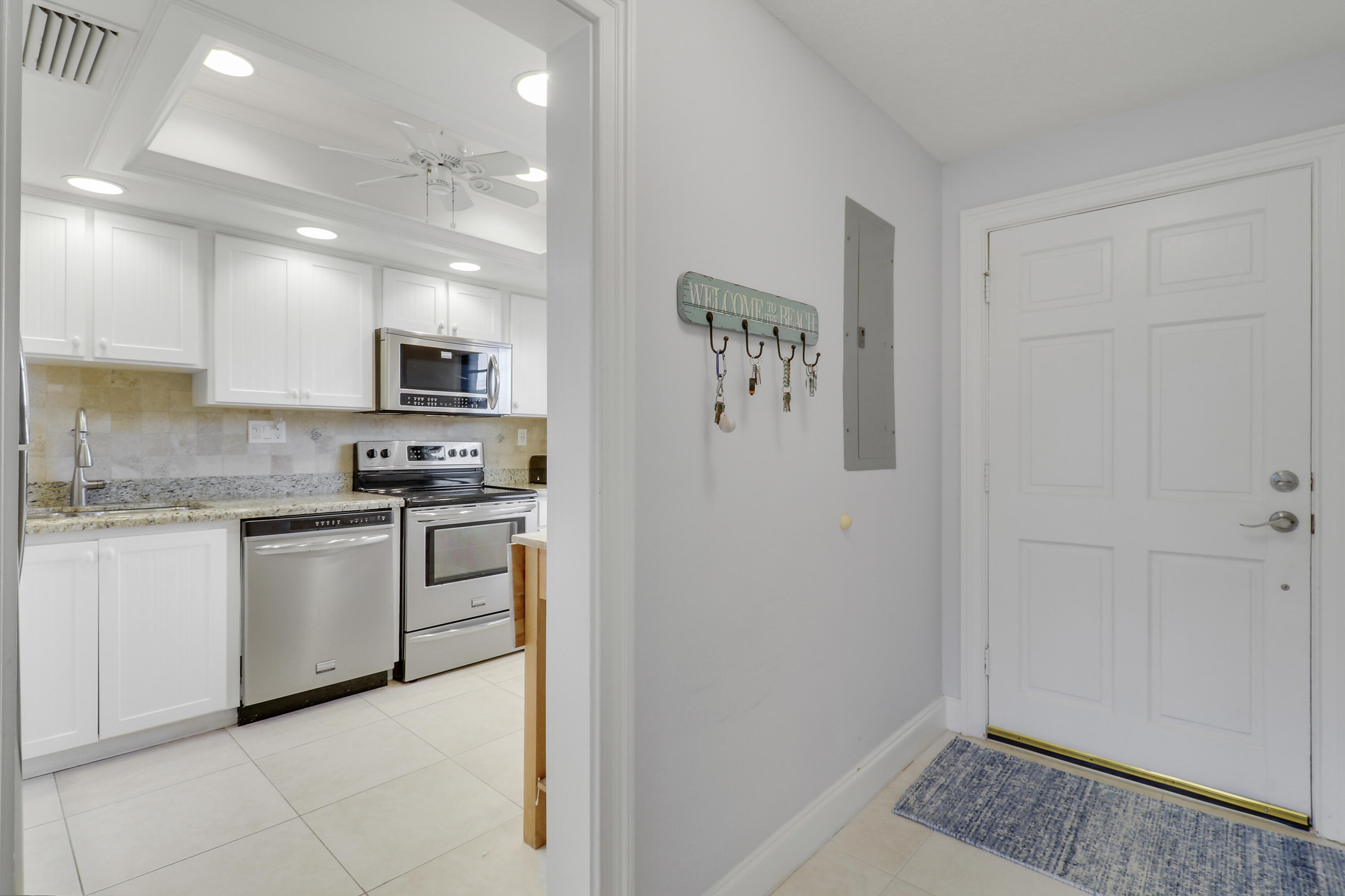 275 South Beach Road, Unit B202 Tequesta, FL 33469 - Photo 28 of 37 a kitchen with white cabinets and white appliances