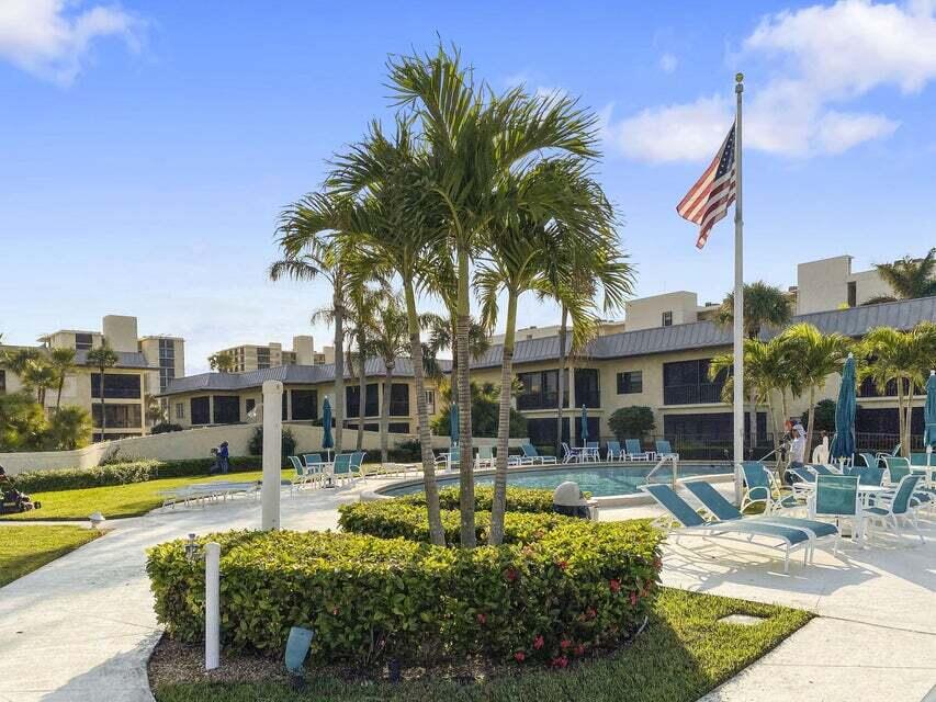 275 South Beach Road, Unit B202 Tequesta, FL 33469 - Photo 4 of 37 a swimming pool with outdoor seating and yard