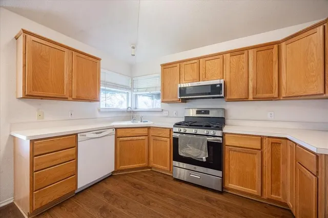 a kitchen with granite countertop a sink cabinets and wooden floor