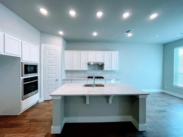 a kitchen with kitchen island stainless steel appliances a sink and stove