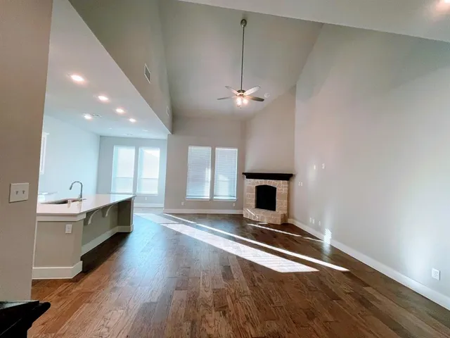 wooden floor fireplace and windows in an empty room