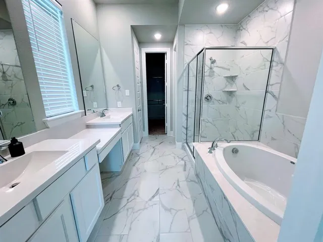 a spacious bathroom with a tub sink a mirror a shower and vanity
