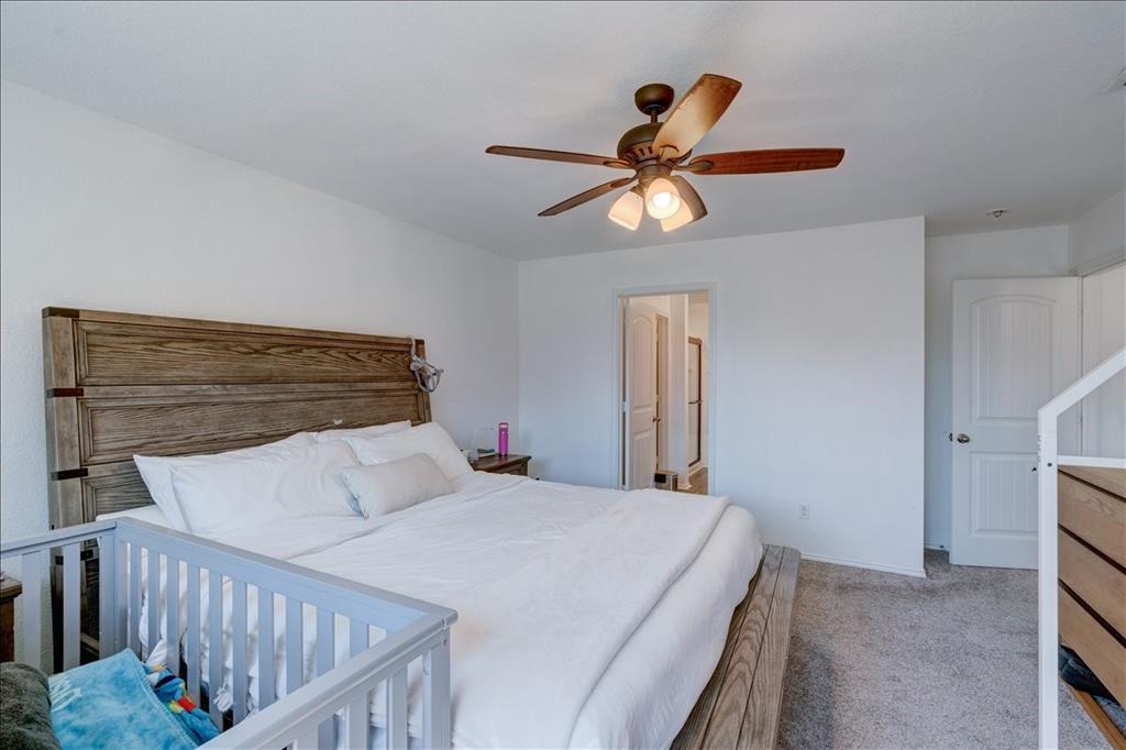 6233 Skysail Road Fort Worth, TX 76179 - Photo 17 of 30 a bedroom with a bed and a chandelier