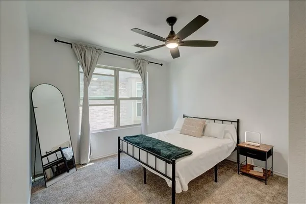 a bedroom with a bed and a chandelier fan