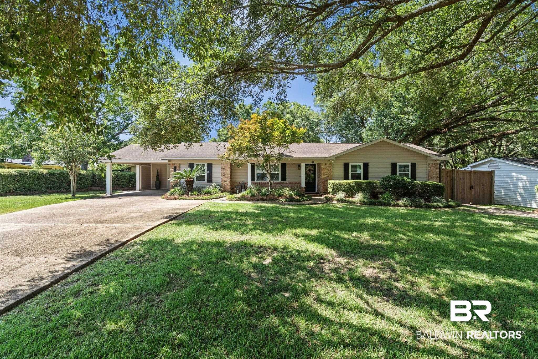 101 Ann Street Daphne, AL 36527 - Photo 31 of 38 Ranch-style exterior featuring a covered carport, stone-accented facade, and dark shutters