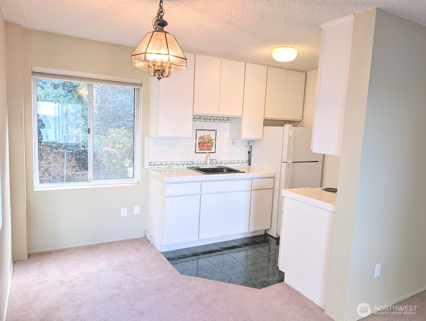 1156 Alki Avenue Southwest, Unit 201 Seattle, WA 98116 - Photo 11 of 40 a kitchen with a refrigerator a stove and a window