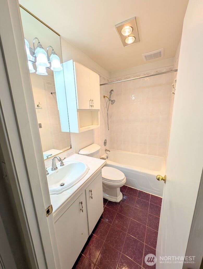 1156 Alki Avenue Southwest, Unit 201 Seattle, WA 98116 - Photo 16 of 40 a bathroom with a granite countertop sink toilet a mirror and shower