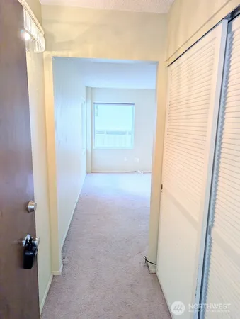 an empty room with windows and closet