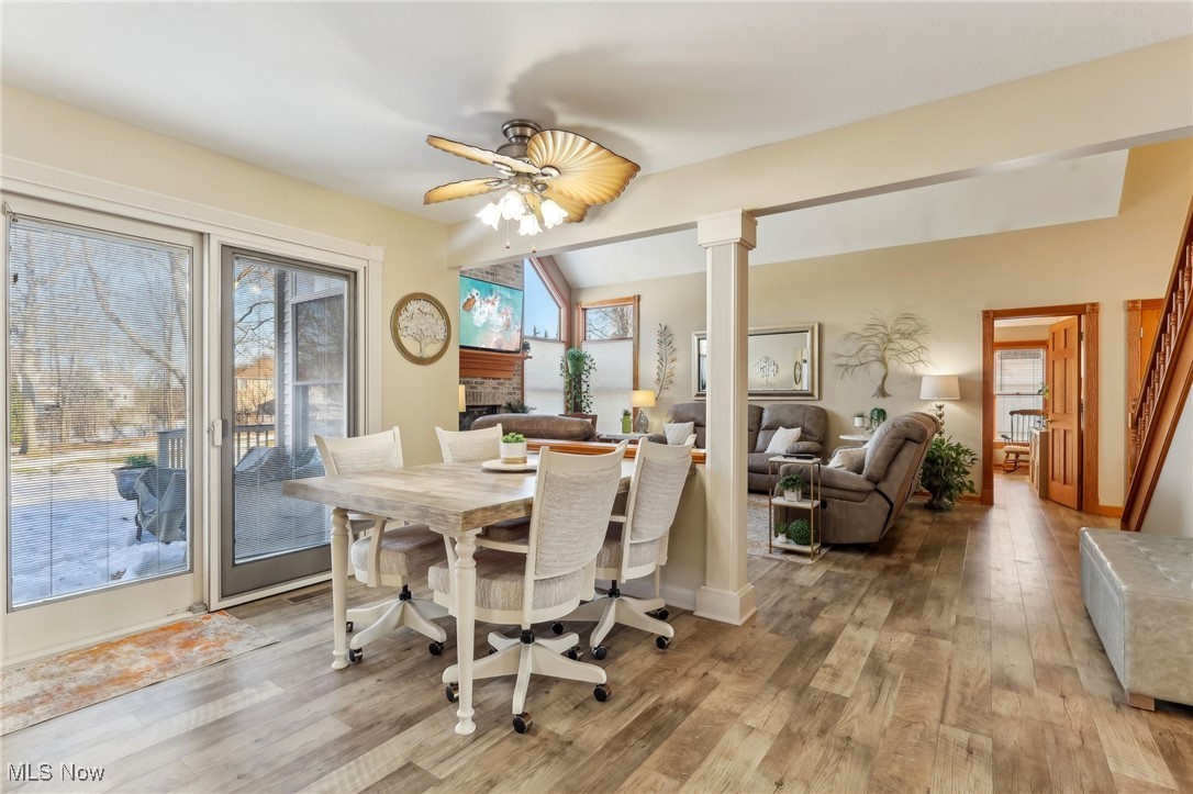 3353 Jens Way Perry, OH 44081 - Photo 13 of 49 Dining room with vaulted ceiling, a fireplace, decorative columns, ceiling fan, and light hardwood / wood-style flooring