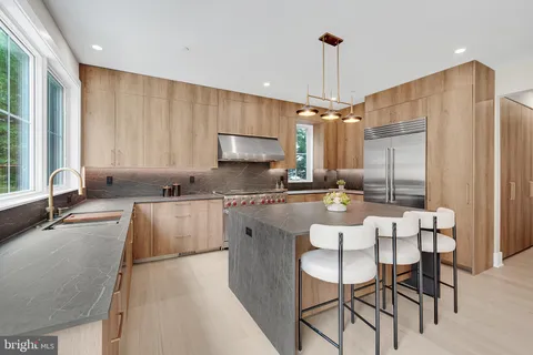a large kitchen with stainless steel appliances granite countertop a sink and a refrigerator