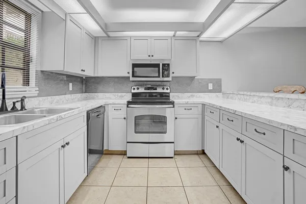 a kitchen with cabinets stainless steel appliances and sink