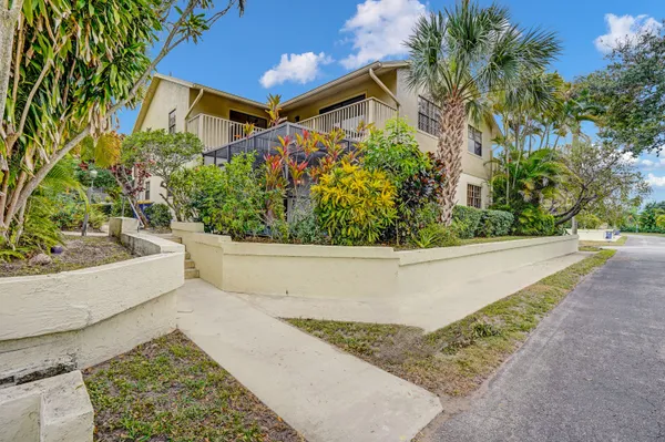 a view of a house with a yard and potted plants