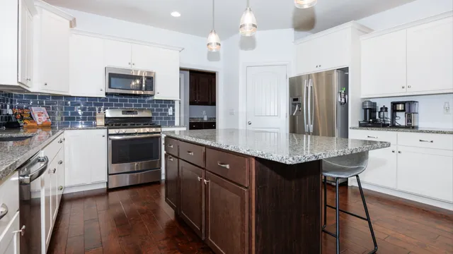 a kitchen with a table chairs refrigerator and microwave