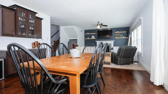 a kitchen with stainless steel appliances granite countertop a sink dishwasher a stove and a dining table with wooden floor