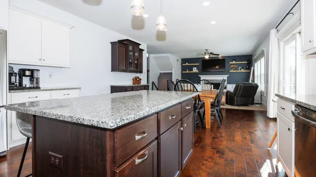 a kitchen with stainless steel appliances granite countertop a sink window and cabinets