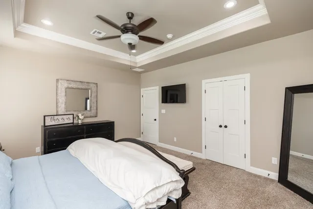 a bedroom with a large bed and a chandelier