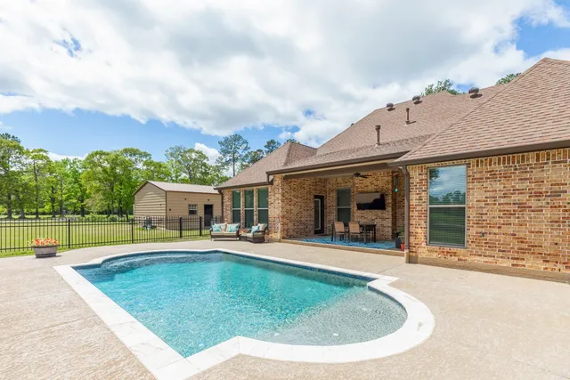 swimming pool view with a seating space and a garden view