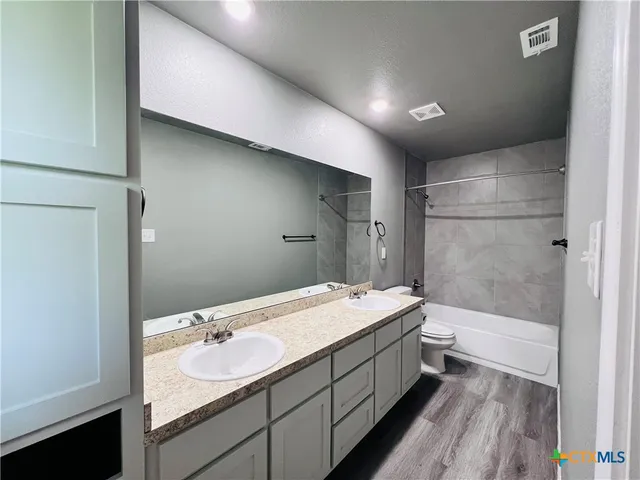 a bathroom with a double vanity sink toilet and shower