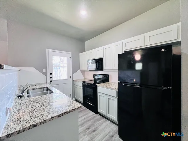 a kitchen with a sink stainless steel appliances and counter space
