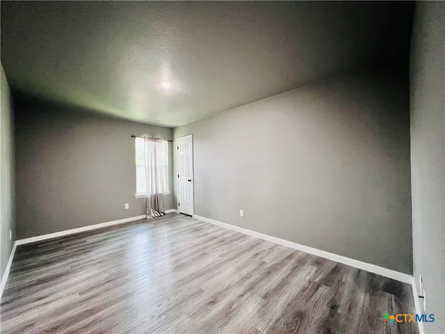 a view of room with window and wooden floor