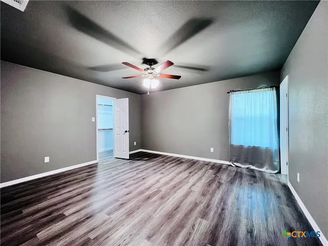 a view of an empty room with wooden floor