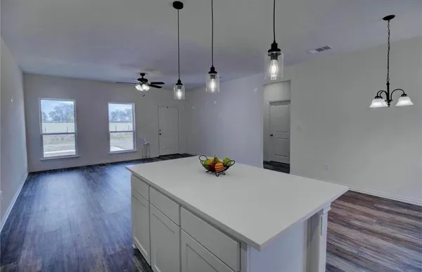 a kitchen that has a sink a stove and a wooden floor