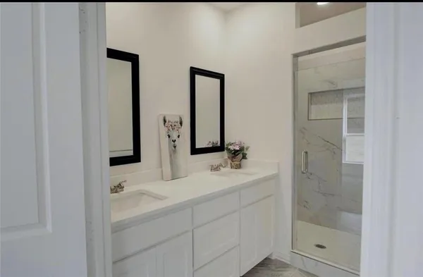 a bathroom with double vanity sink and mirror