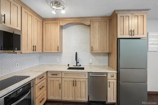 a kitchen with stainless steel appliances granite countertop a refrigerator sink and cabinets