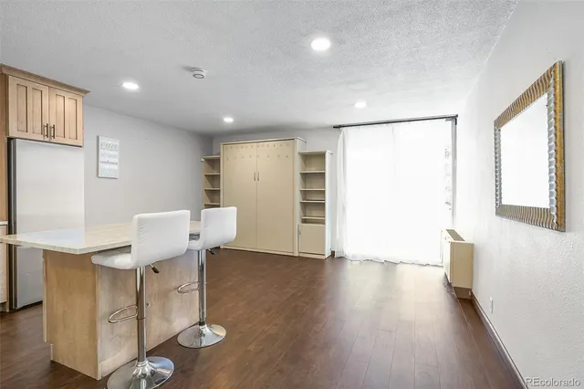 a view of a kitchen with furniture and wooden floor