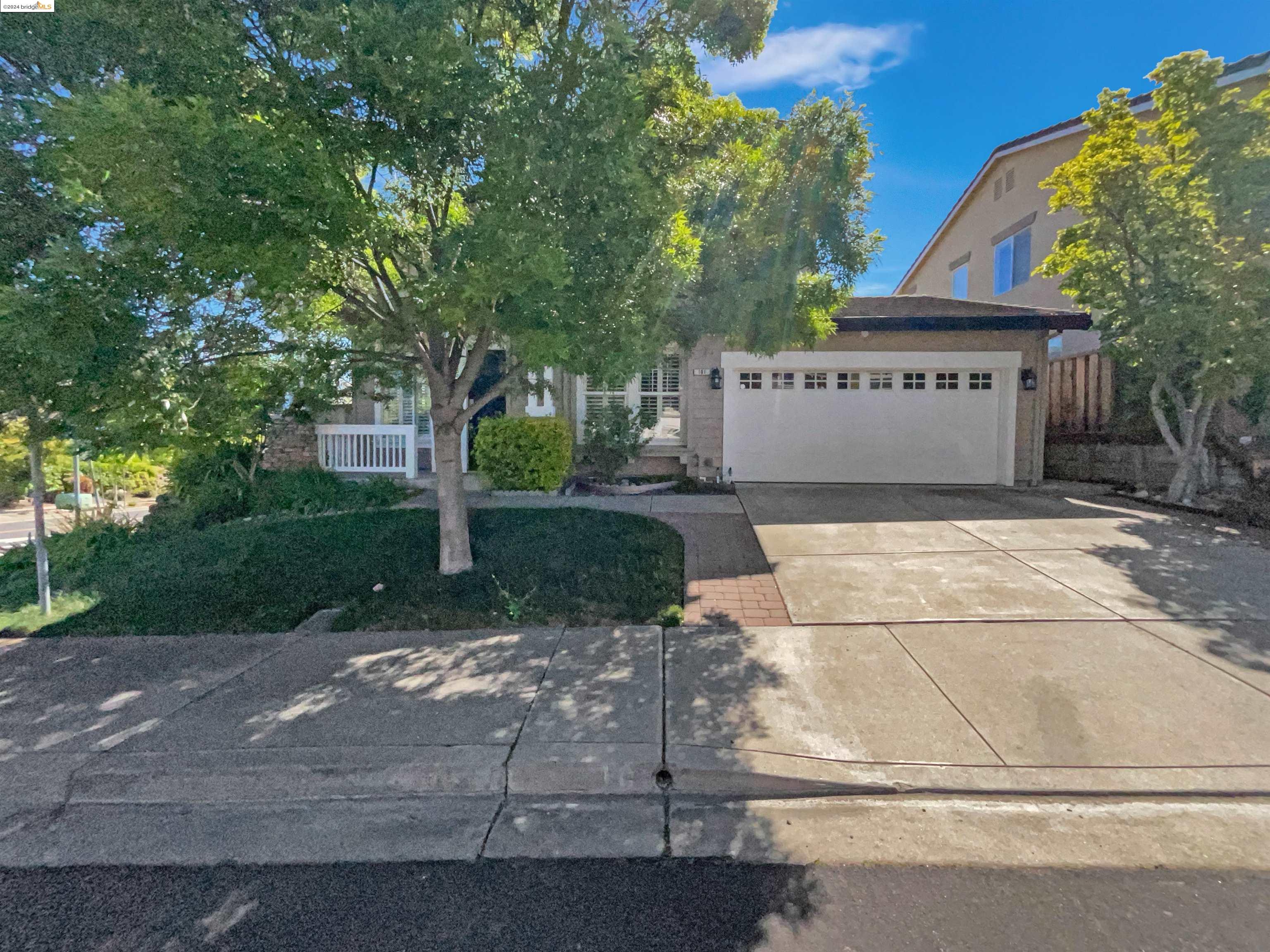 a view of a house with a yard and large tree